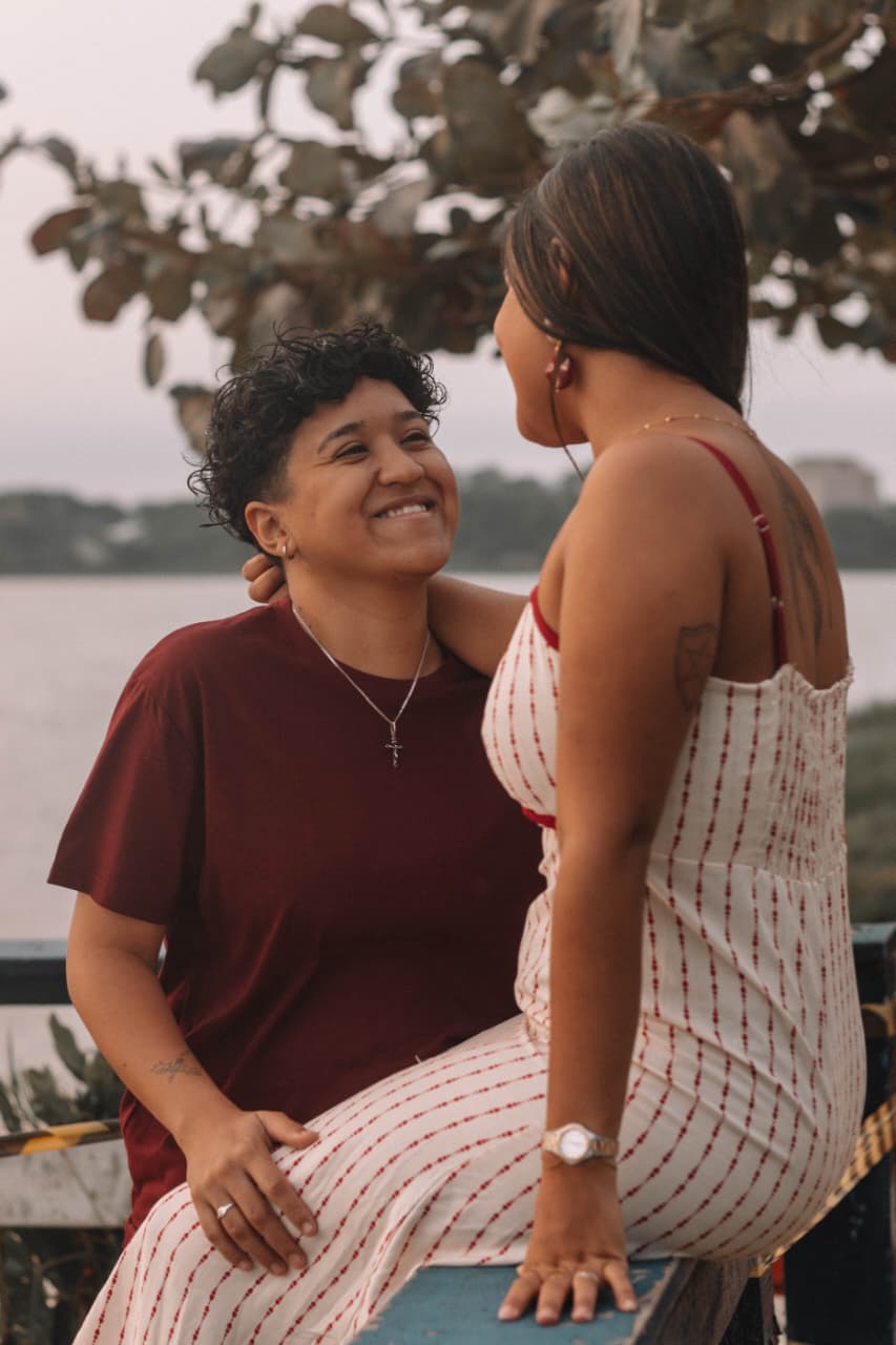 Casal sorrindo em ensaio à beira-mar