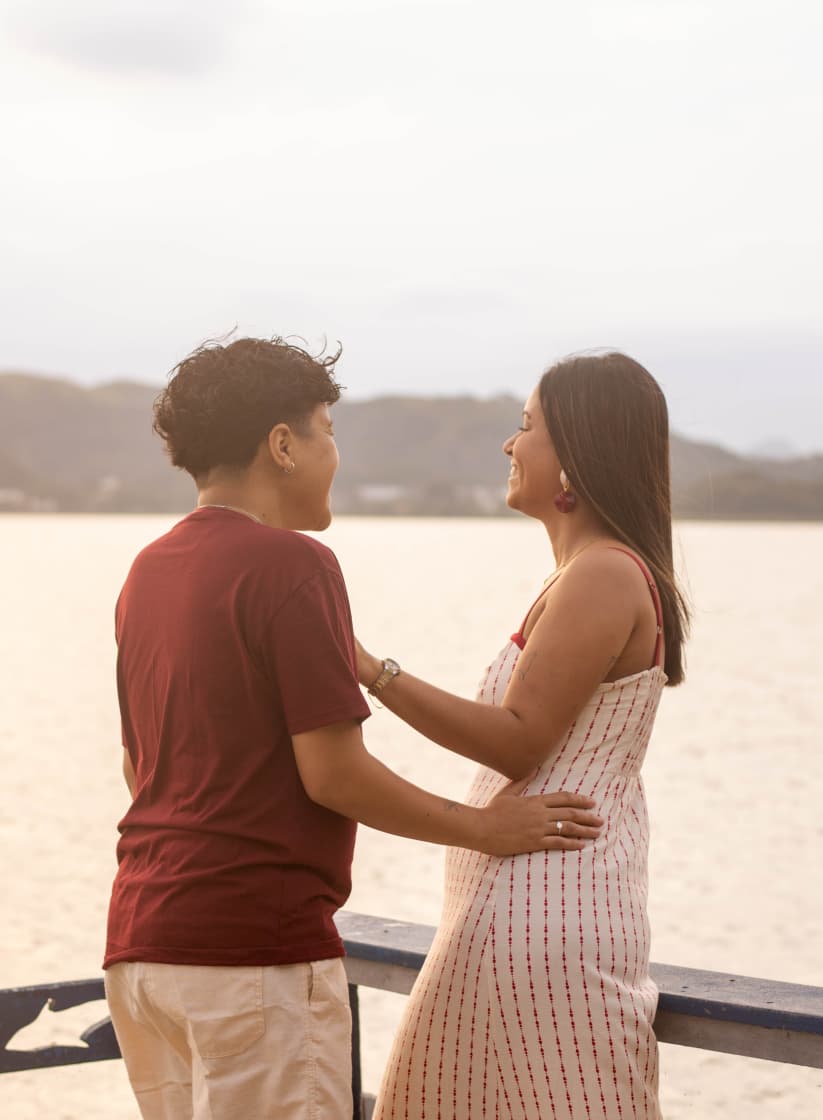 Casal ao entardecer olhando para o mar