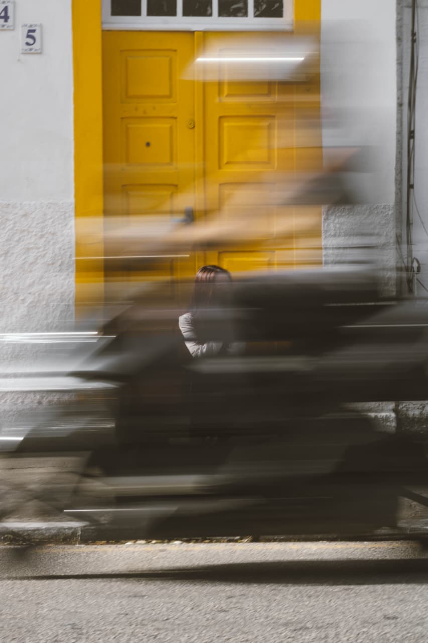 Porta amarela com motos passando em movimento