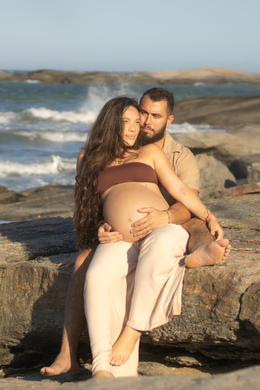 Casal abraçado nas pedras, gestante